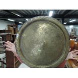 A large circular brass tray, probably indian, diameter approx. 60cm