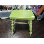 A traditional low milking style stool painted in green