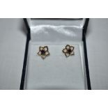 A pair of 9ct gold stud earrings having sapphire chips in open petal surrounds, approx 1g