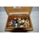 A small treen box containing a selection of earrings including ceramic, marcasite etc