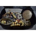 A vanity case containing a selection of costume jewellery