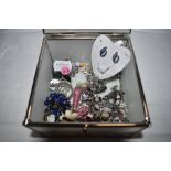 A decorative box containing a selection of stud and clip fashion earrings etc