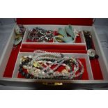 A jewellery box containing a selection of costume jewellery including Ensign watch, brooches,strings