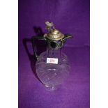 A cut glass claret jug of oval form having chequered decoration and plated handle and lid with