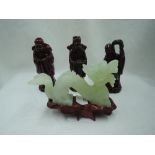 A hand carved figure of a Chinese dragon in a pale green jade and similar figures