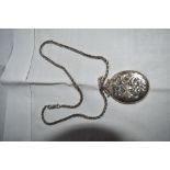 An HM silver locket having engraved scroll decoration on a snake link chain