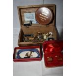 A treen box containing a selection of cufflinks, tie clips, tie tacs, etc