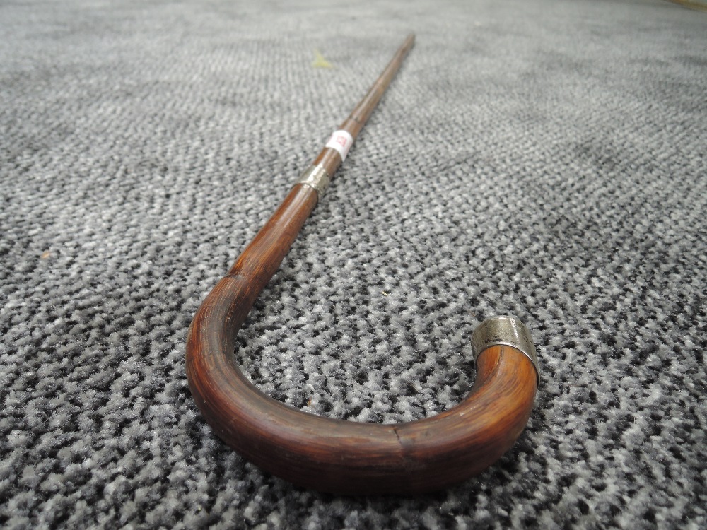 A bent wood bamboo walking cane having HM silver ferrule and tip