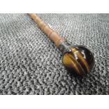 A bamboo shafted walking cane having HM silver ferrule holding Tigers eye stone globe handle