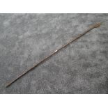 A tribal spear having solid wood shaft with wrought iron head and guards measuring 180cm long
