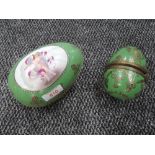 Two ceramic Russian style eggs having cherub decoration with green ground and gold detailing