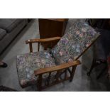 A vintage wood frame recliner chair, having later morris style upholstery