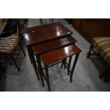 An early 20th Century mahogany and line inlaid nest of three tables on shaped legs, width of largest