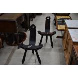 A pair of interesting rustic chairs , on tripod legs with clover motifs