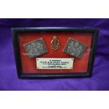 A framed WW2 Memorial consisting of two shoulder badges, cap badge and plaque reading In Memoriam