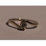 A lady's diamond solitaire dress ring, approx 0.1ct in a raised claw mount to crossover shoulders on