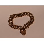 A rose gold curb chain bracelet having alternate decorative links and a padlock clasp stamped 9C,