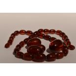 A string of cherry amber style graduated beads having broken barrel clasp, with 3 extra beads