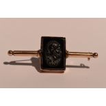 A rose gold bar brooch having a rectangular onyx intaglio panel to centre depicting a centurian,