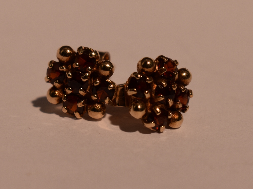 A pair of 9ct gold stud earrings having garnet decoration, approx 2.2g