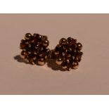 A pair of 9ct gold stud earrings having garnet decoration, approx 2.2g