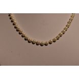 A string of cultured pearls of even form having a yellow metal clasp stamped 9K, approx 16'