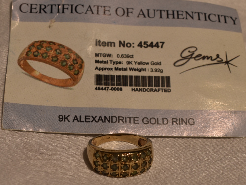 A lady's band ring having a triple row of alexandrite in a chequered mount on a 9ct gold loop, - Image 2 of 2