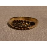 A lady's dress ring having five small old cut diamonds in a pave set boat mount on a yellow metal