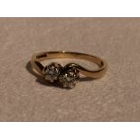 A lady's dress ring having two diamonds, each approx 0.1ct in claw set mounts to crossover shoulders