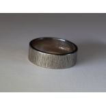 An 18ct white gold wedding band having bark effect decoration, size L & 6g