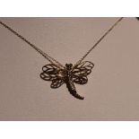 A 9ct white and yellow gold pendant modelled as a dragonfly on a 9ct gold fine link chain, approx