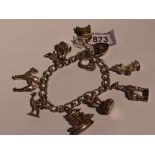 A silver charm bracelet with padlock clasp having eight white metal charms including camel, emu,