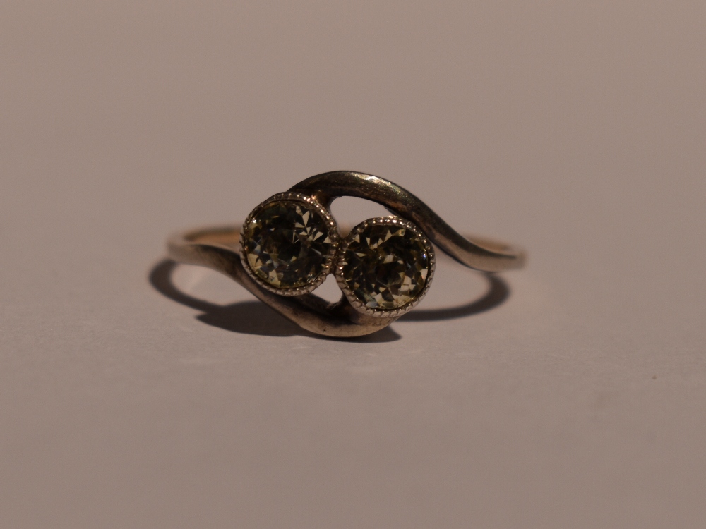 A lady's dress ring having a duo of spinels in collared mounts to cross over shoulders on a yellow