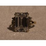 A lady's dress ring having a baguette cut cubic zirconia flanked by two rows of four round cut CZ to