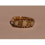 A lady's dress ring having three graduated opals interspersed by diamond chips in a gallery mount on