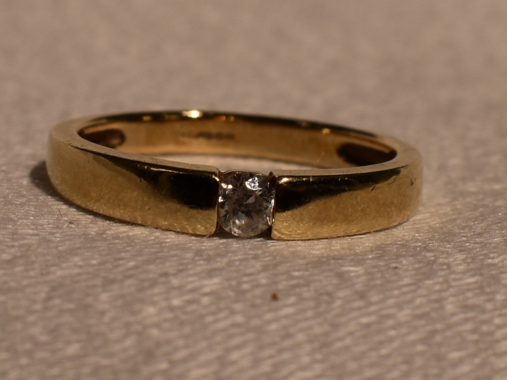 A lady's dress ring having a tension set cubic zirconia in a 14ct gold band, size M &approx 2.7g