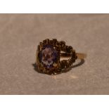 A lady's dress ring having an oval amethyst in a stylised open mount on a 9ct gold loop, size N &