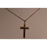 A yellow metal cross stamped 10K having engraved line decoration on a yellow metal chain, approx 2.