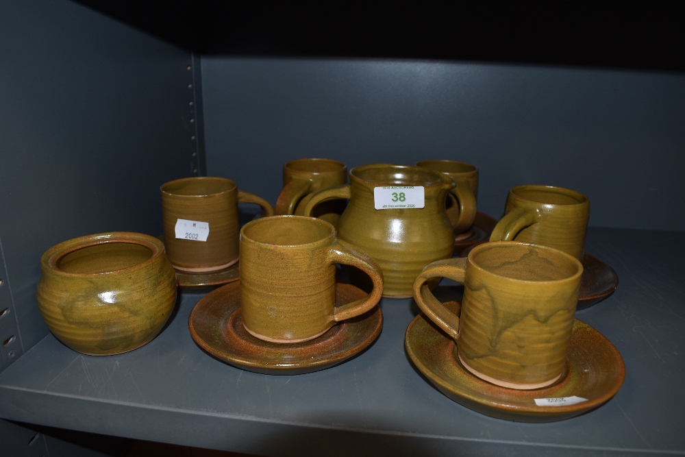 A collection of studio pottery including six cups and saucers,jug and sugar basin.