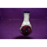 A small baluster shaped Moorcroft vase having pansy design.