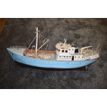 A wooden hand built model steam boat numbered 476, painted in blue and white with brown hull