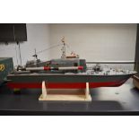 A wooden hand built model radio controlled military boat, painted in grey and with red hull having