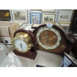 A vintage mantel clock and another in the shape of portal.