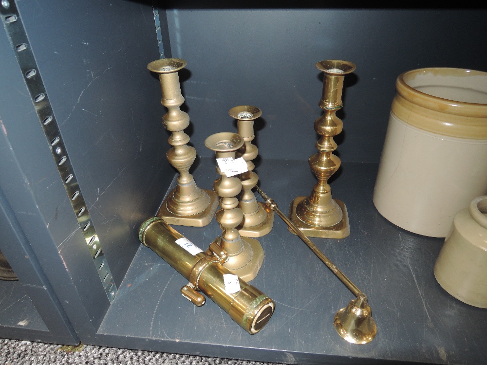 Four brass candle stick holders,a snuffer and a Brass maritime torch possibly a divers torch 'The