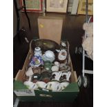 A box containing mugs, vintage cups and saucers and vases, brass tray and more.