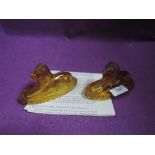 Two amber press moulded glass lion paperweights.AF