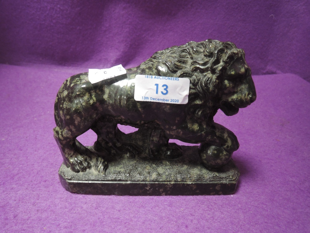 A carved lion with sphere under paw in a green specked polished stone,around early 20th century.