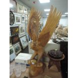 An impressive hand carved wooden figure of an American Bald Eagle standing at 87cm approx