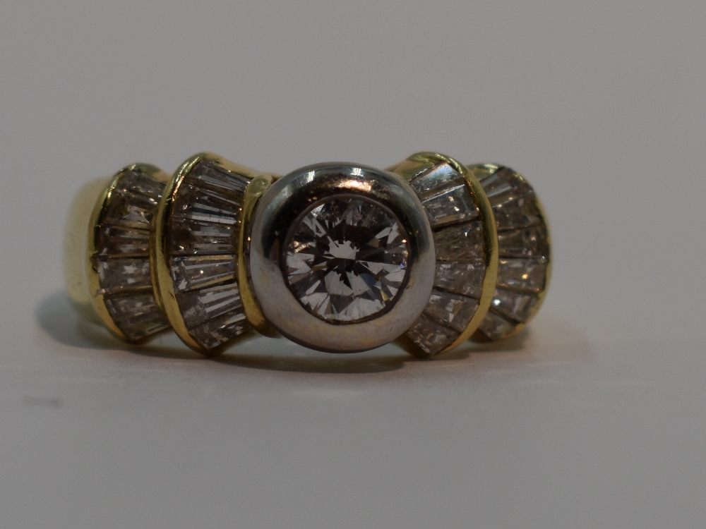 A lady's dress ring having a central diamond, approx 0.5ct to baguette diamond set stepped fanned