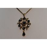 An Edwardian style 9ct gold pendant having central sapphire and diamond cluster in a diamond and